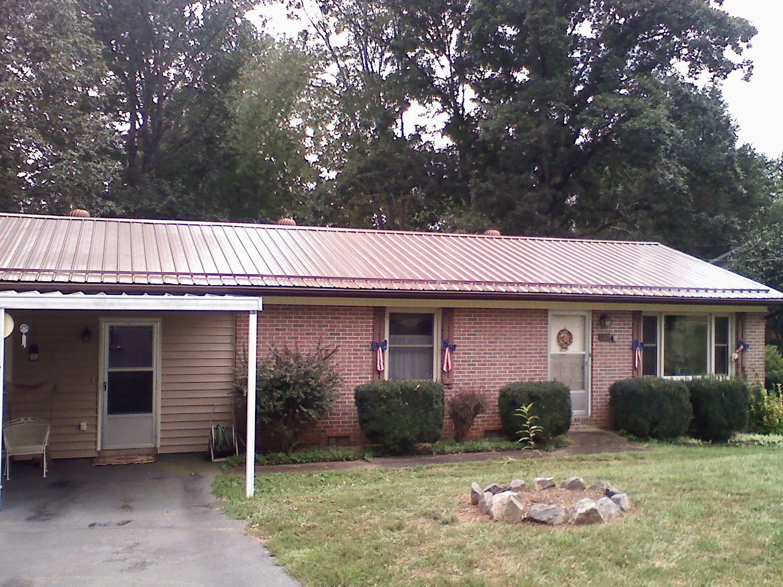 Bronze metal roof and carport on a brick ranch home — Roof Repair work by our crew in Montague