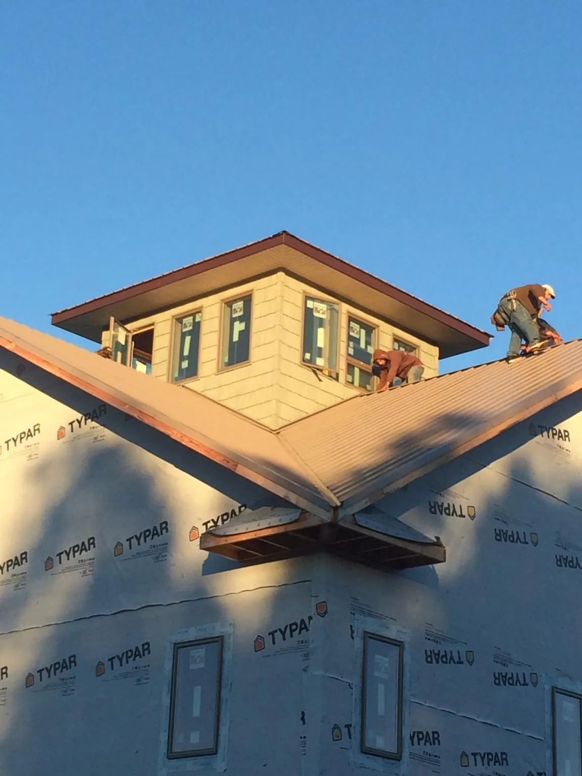 Roofers working around a rooftop cupola on a new metal roof at sunset — Roof Waterproofing in Montague by Roofing Brothers